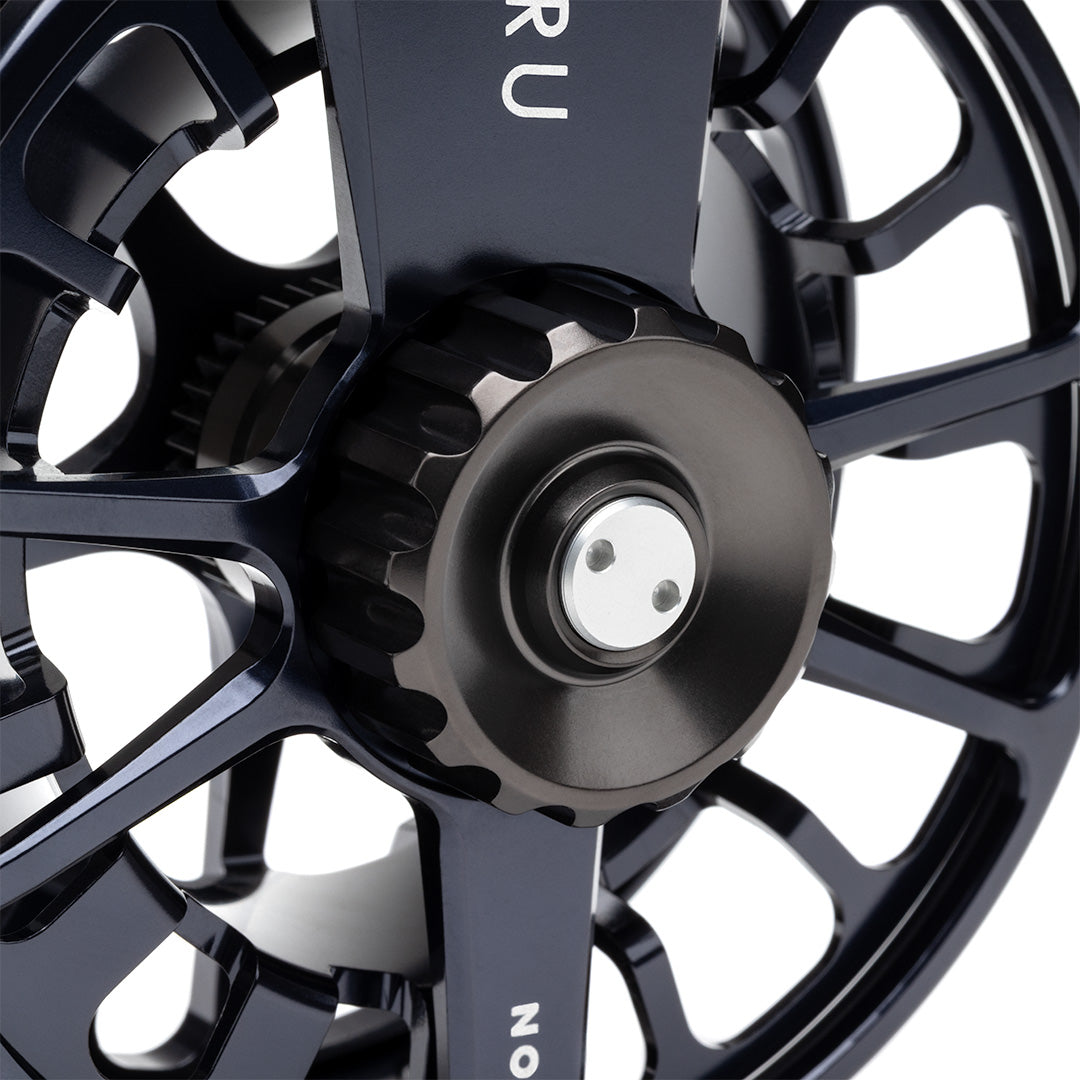 Lamson Guru X black fly reel featuring precision-machined center with dual-pawl drag system and ventilated disc design