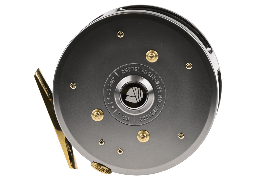 Redington Classic Spey fly reel with gunmetal gray finish, brass reel foot, and brass crank handle on white background