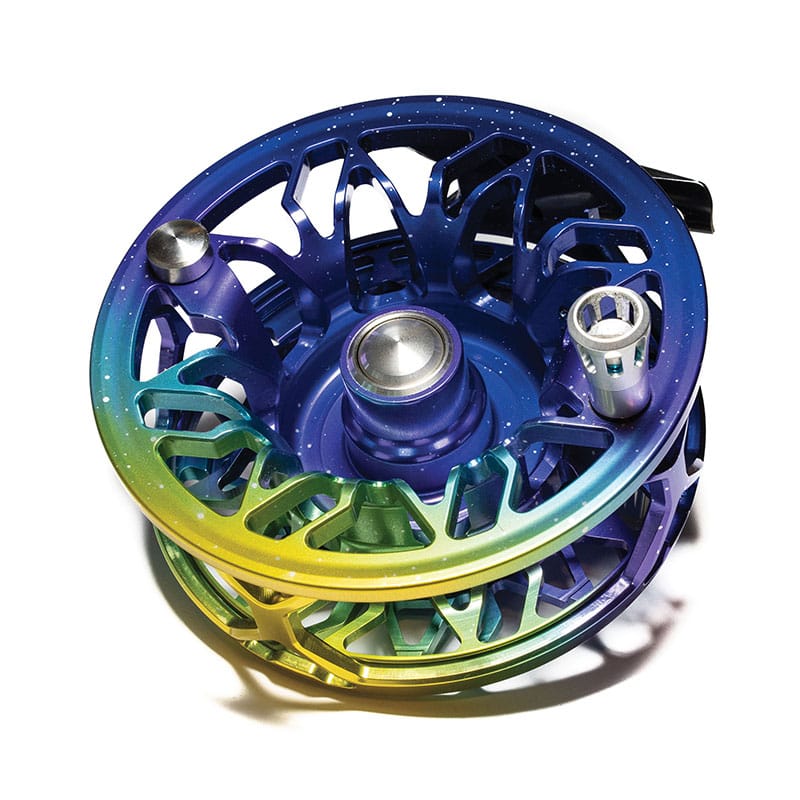 Abel Rove fly reel in anodized blue-to-green-to-yellow gradient aluminum with skeletal spool design and speckled finish