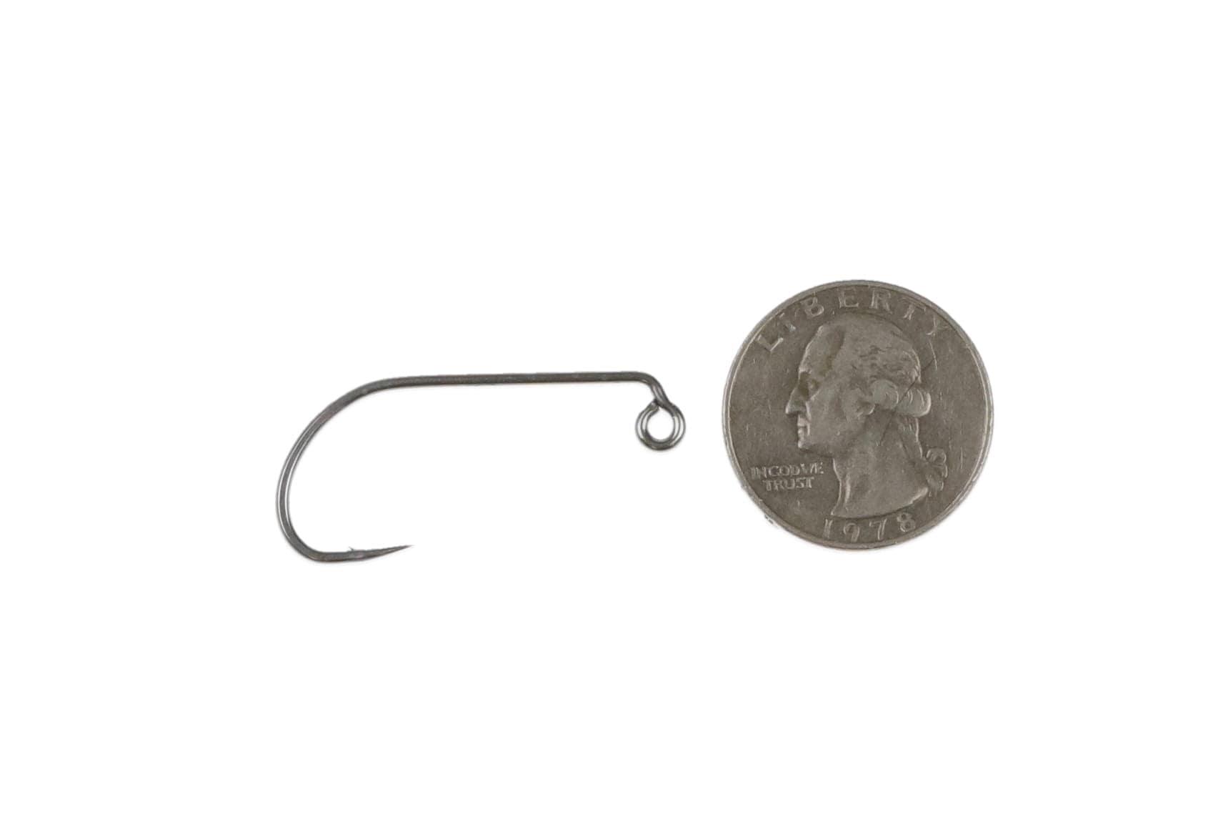 Ahrex SA254 matte black nickel salt jig hook with up-eye and curved short shank, fly tying hook beside U.S. quarter