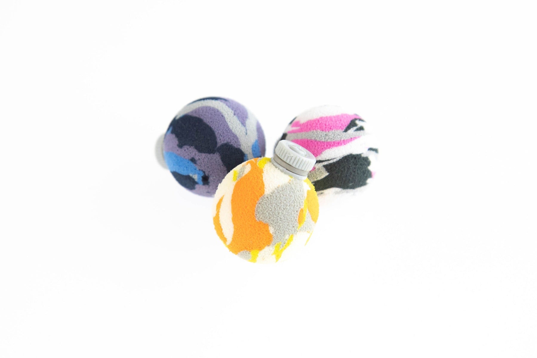 Three Airlock foam strike indicators with camouflage patterns (yellow/orange, purple/blue, pink/white) and gray valve cap