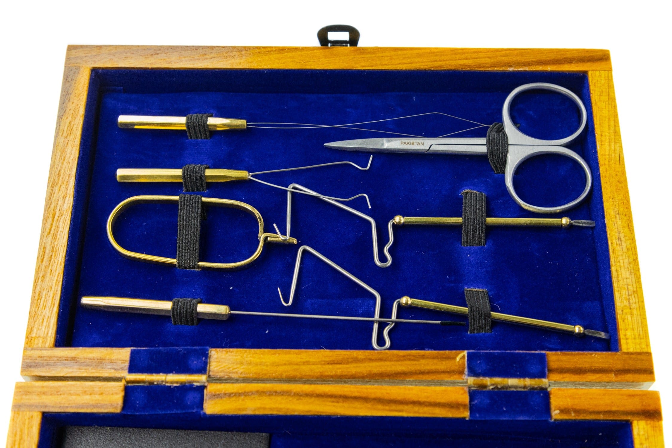 Wooden case with royal blue velvet lining holding brass and steel fly-tying tool kit, scissors and pedestal parts