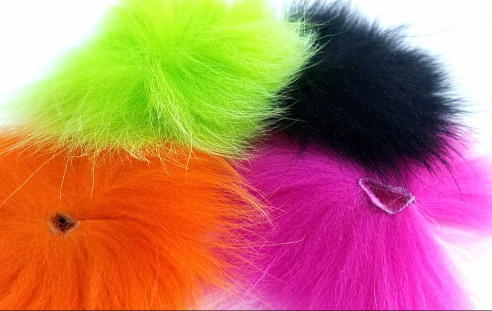 Fluffy Arctic Fisherman Blue Fox fox fur poms in neon orange, chartreuse, hot pink and black for fly tying