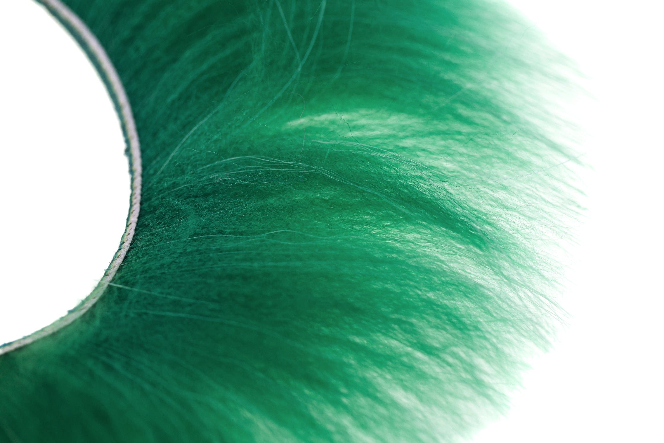 Emerald green raccoon zonker strip with long soft fur fibers on adhesive backing for fly tying