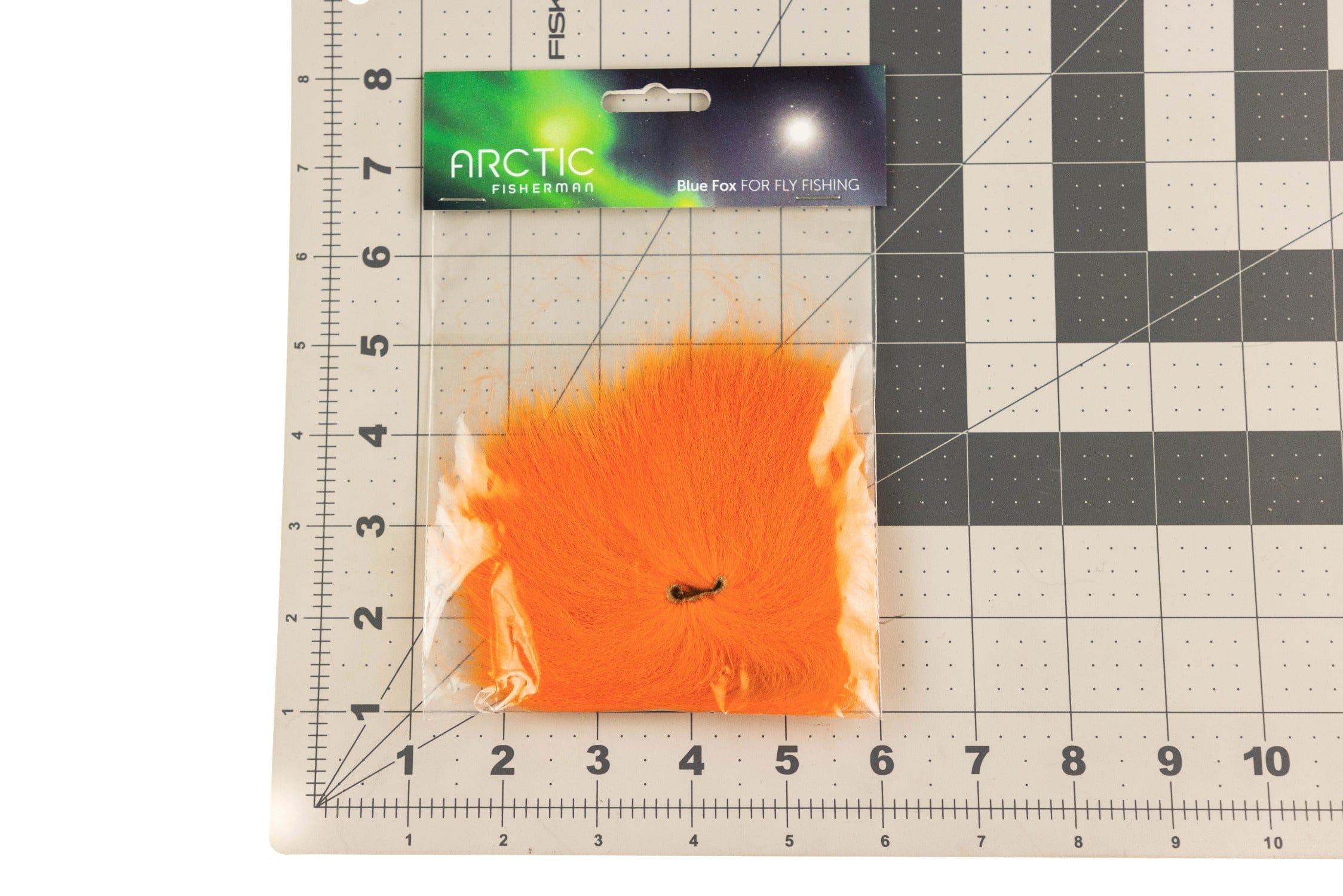 Bright orange Arctic Fisherman mutation fox hair for fly tying, soft long fur in clear pack with green header on grid mat