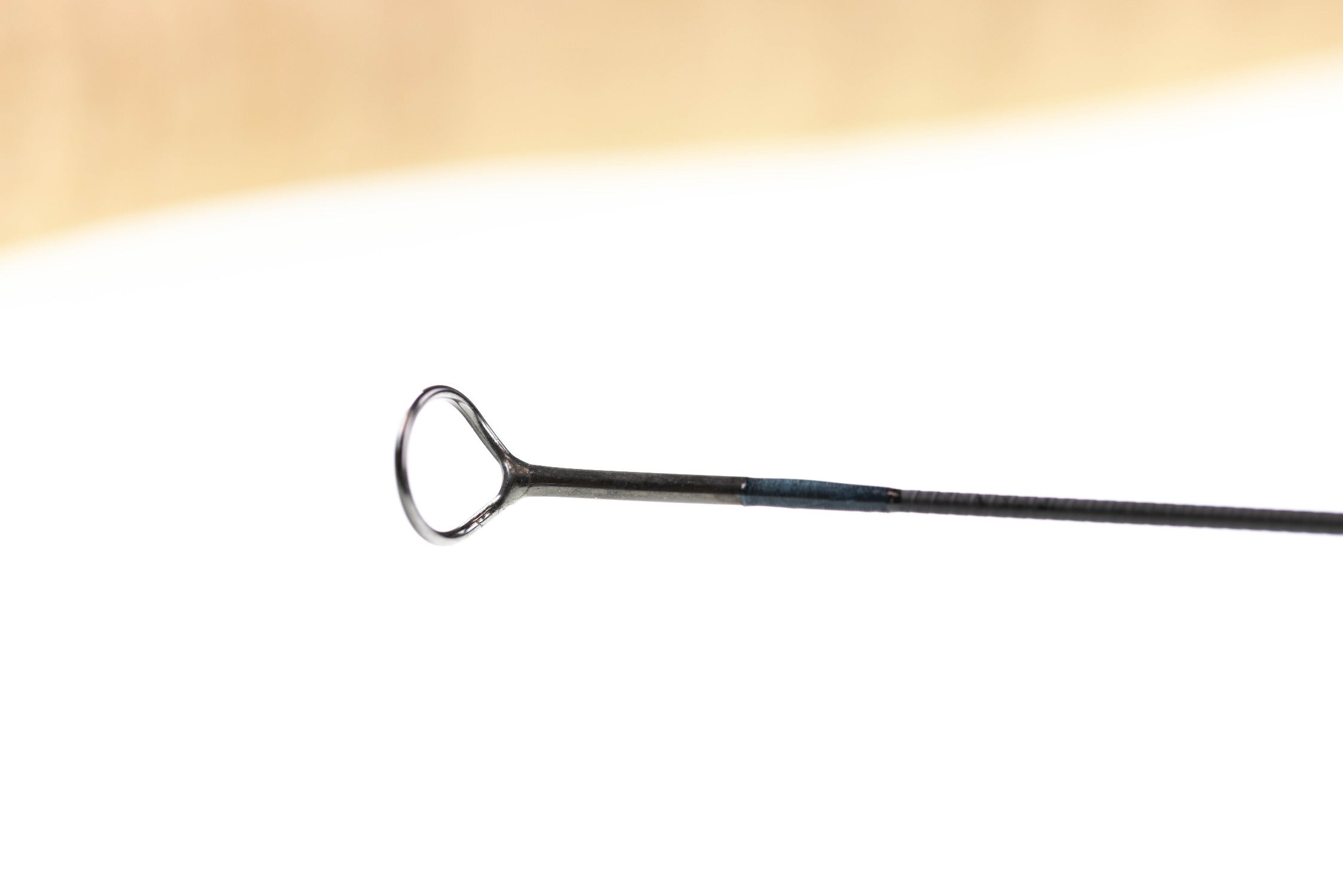 Atlas fly rod tip: metallic silver tip-top guide on black graphite blank with blue thread wrap