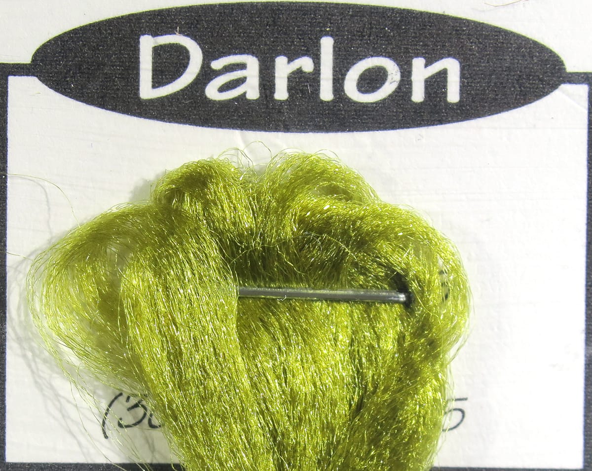Olive green Darlon synthetic fiber bundle with metallic sheen pinned to Ds Flyes fly tying card