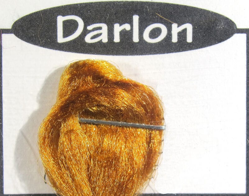 Golden orange Darlon synthetic fly tying fiber bundle on white Ds Flyes card, shiny strands