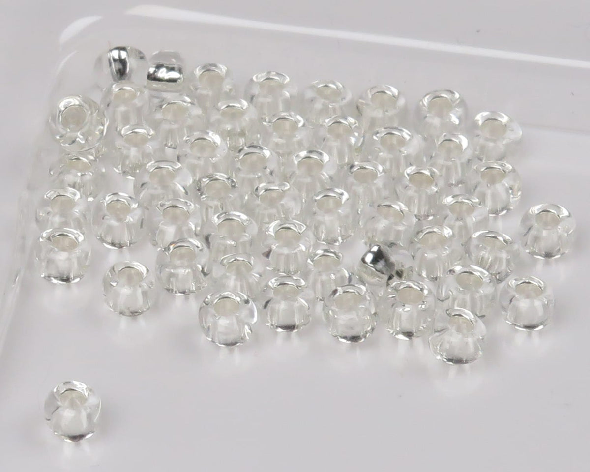 Clear glass beads for fly tying, small transparent round beads with wide holes on white background
