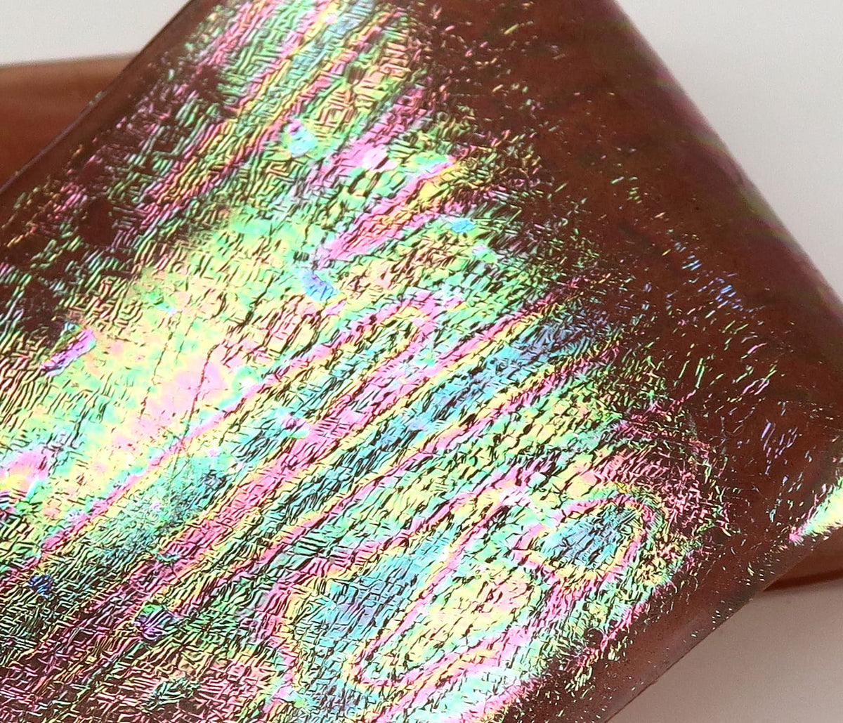 Iridescent UV chewee skin for fly tying, crinkled holographic brown film with rainbow green, pink and blue reflections