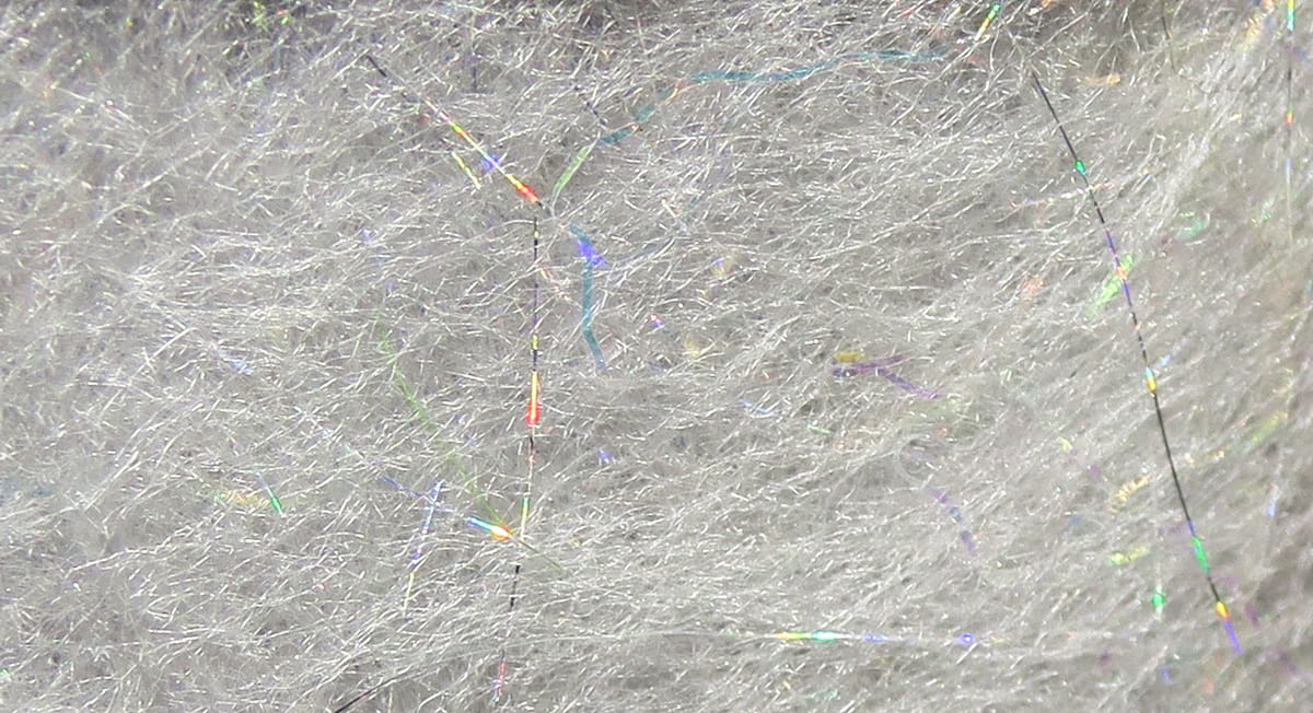 Light gray Jr. Bruiser dubbing blend with fluffy synthetic fibers and holographic tinsel strands for fly tying