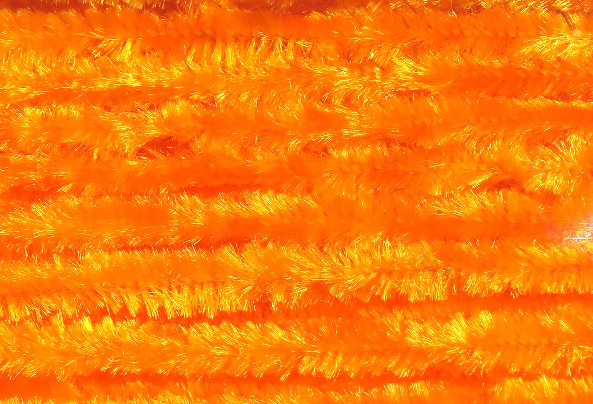 Bright fluorescent orange Hareline chenille with fuzzy, iridescent synthetic fibers for fly tying
