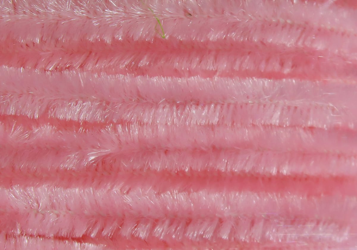 Pink Hareline chenille strands with soft, shiny synthetic fibers arranged in parallel rows for fly tying