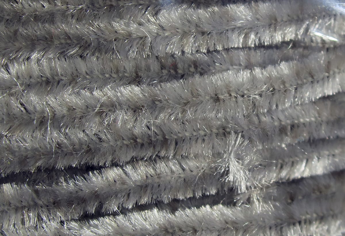 Silver-gray chenille with fuzzy metallic fibers, close-up of textured strands for fly tying