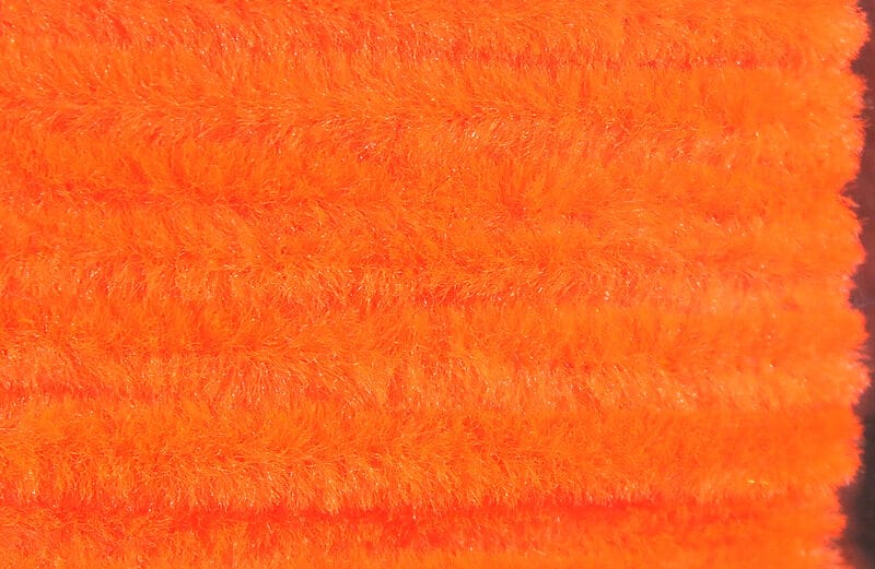 Bright fluorescent orange Hareline chenille for fly tying, fuzzy synthetic yarn with dense plush pile texture