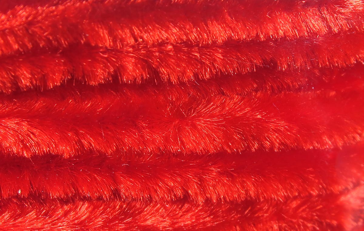 Bright red Hareline chenille with dense shiny fur-like fibers, close-up fly tying material for streamer and lure bodies
