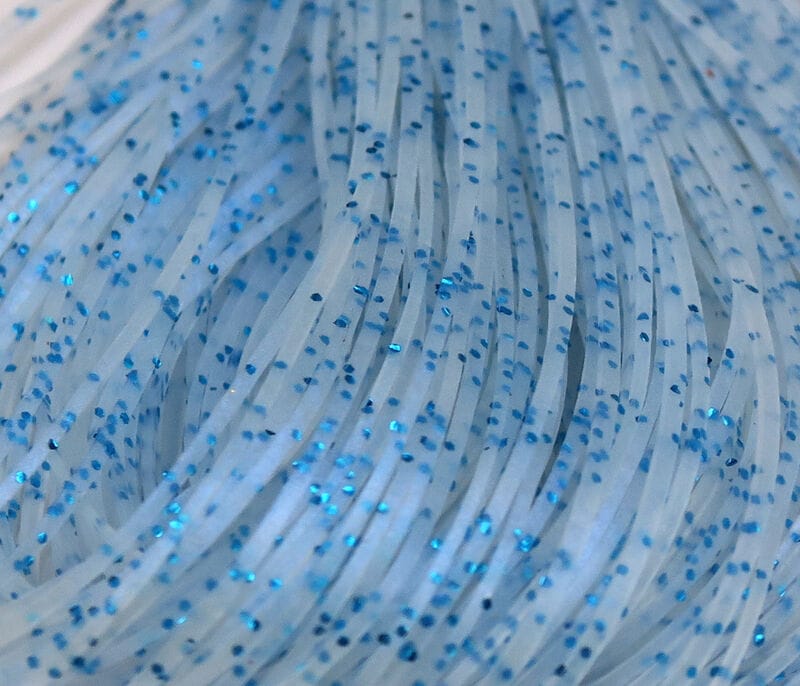 Hareline translucent silicone skirt strands with scattered bright blue glitter flecks for fly tying