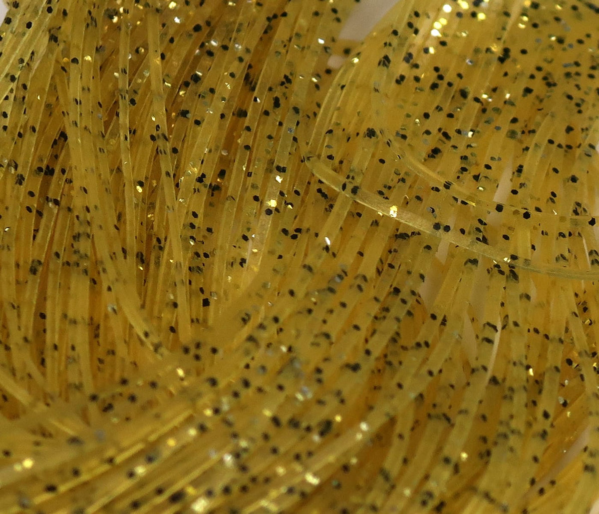 Translucent golden-yellow rubber strands with black specks and gold glitter, Hareline Crazy Legs fly tying material