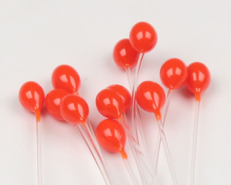 Glossy orange epoxy crab eyes on clear mono stems, round fly tying beads clustered for crab and shrimp patterns