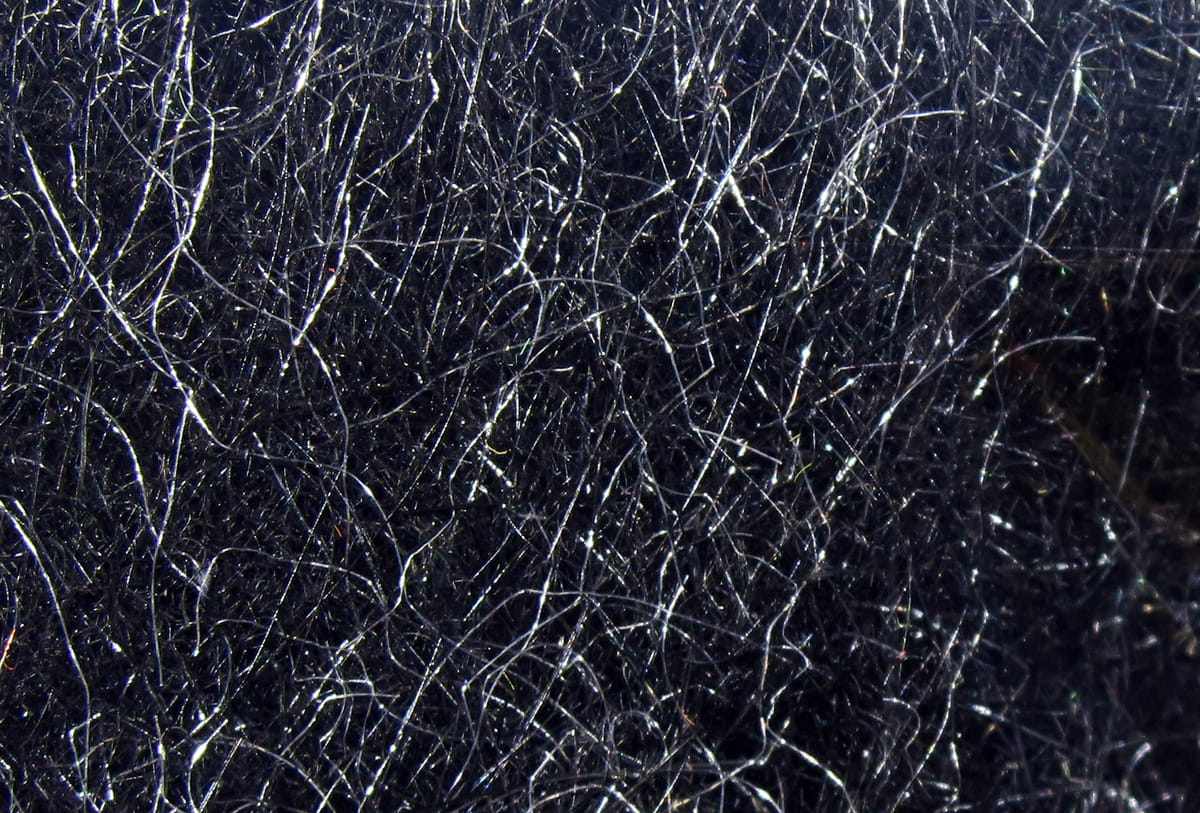 Hareline Hare's Ear Plus dubbing close-up: dark brown-black fur with silvery guard hairs, fine fuzzy texture for fly tying