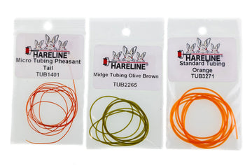 Three Hareline fly tying hollow tubing packs with coiled micro tubing in light orange, olive brown and bright orange