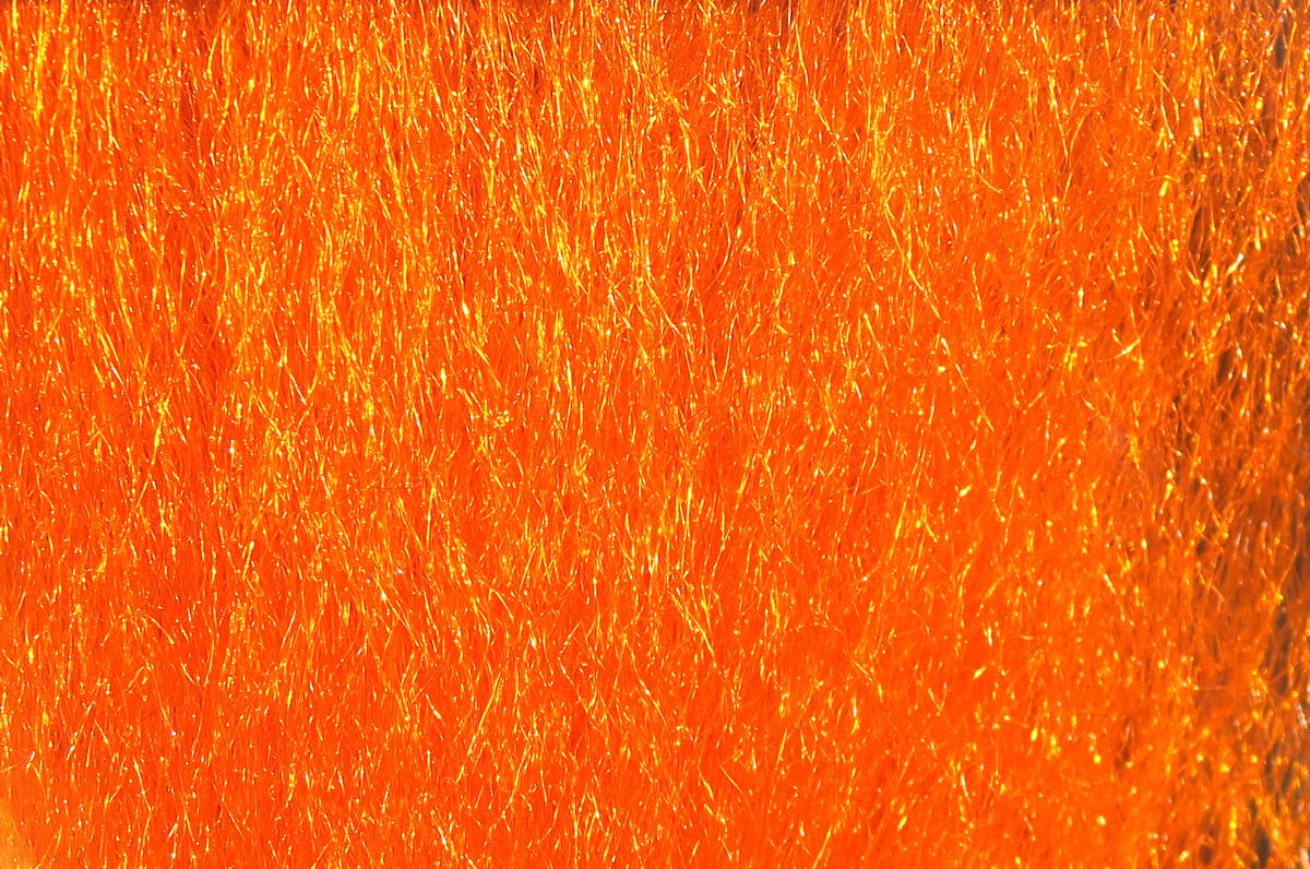 Bright orange Hareline Ice Fur synthetic fly tying fur with fine fibers and gold reflective flash strands