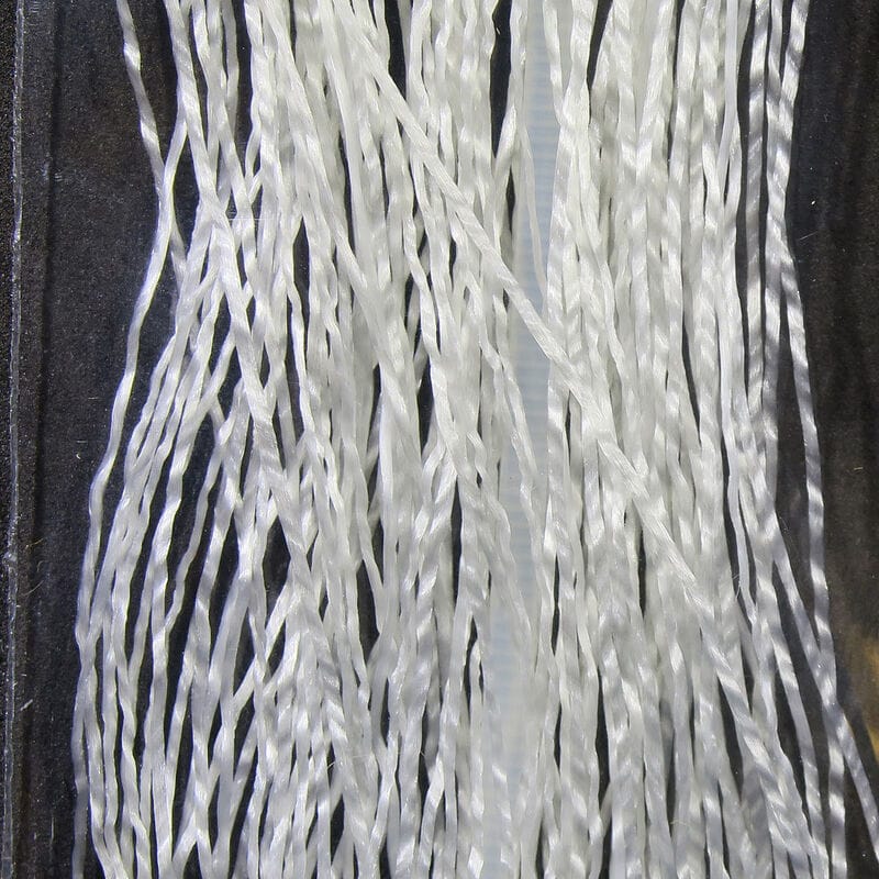 White translucent twisted synthetic Life-Flex strands for fly tying, glossy braided fibers on dark background