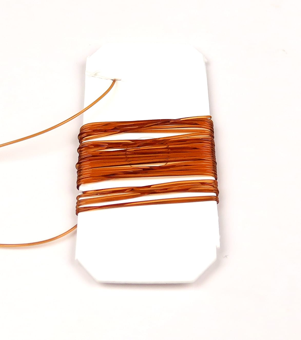 Hareline amber midge stretch rib wound on white card for fly tying