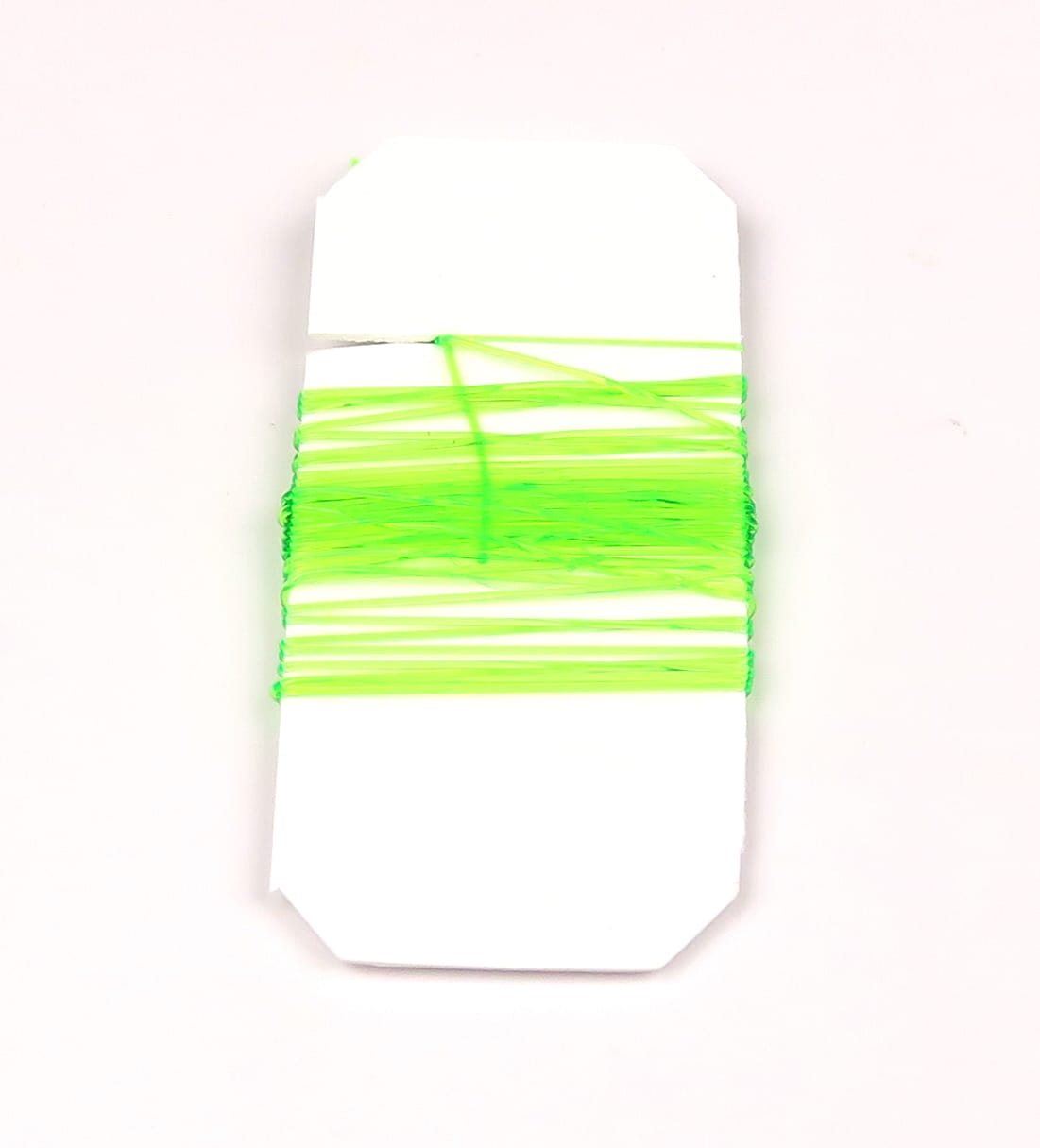 Neon chartreuse Hareline midge stretch rib, thin flexible elastic ribbing wound on white card for fly tying