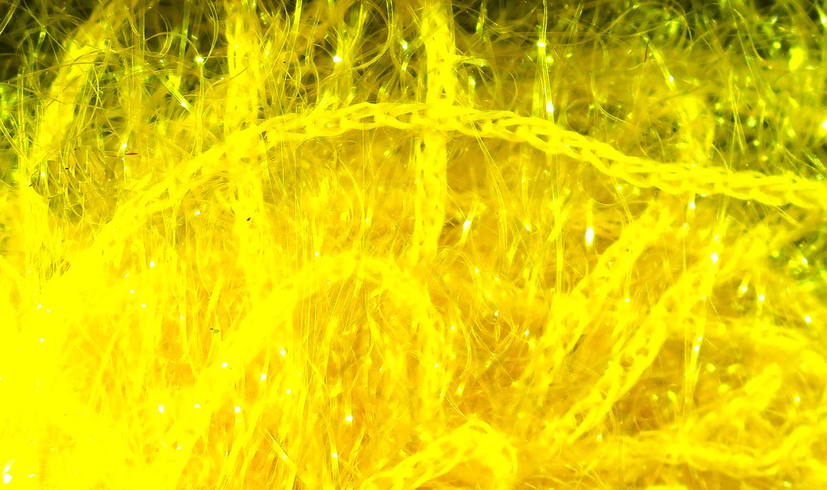 Bright fluorescent yellow Hareline Polar Chenille strands, fluffy synthetic fibers with sparkling tinsel for fly tying
