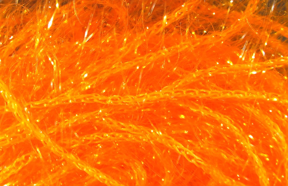 Bright orange Hareline Polar Chenille fly tying material with sparkling iridescent fibers and fluffy chenille strands