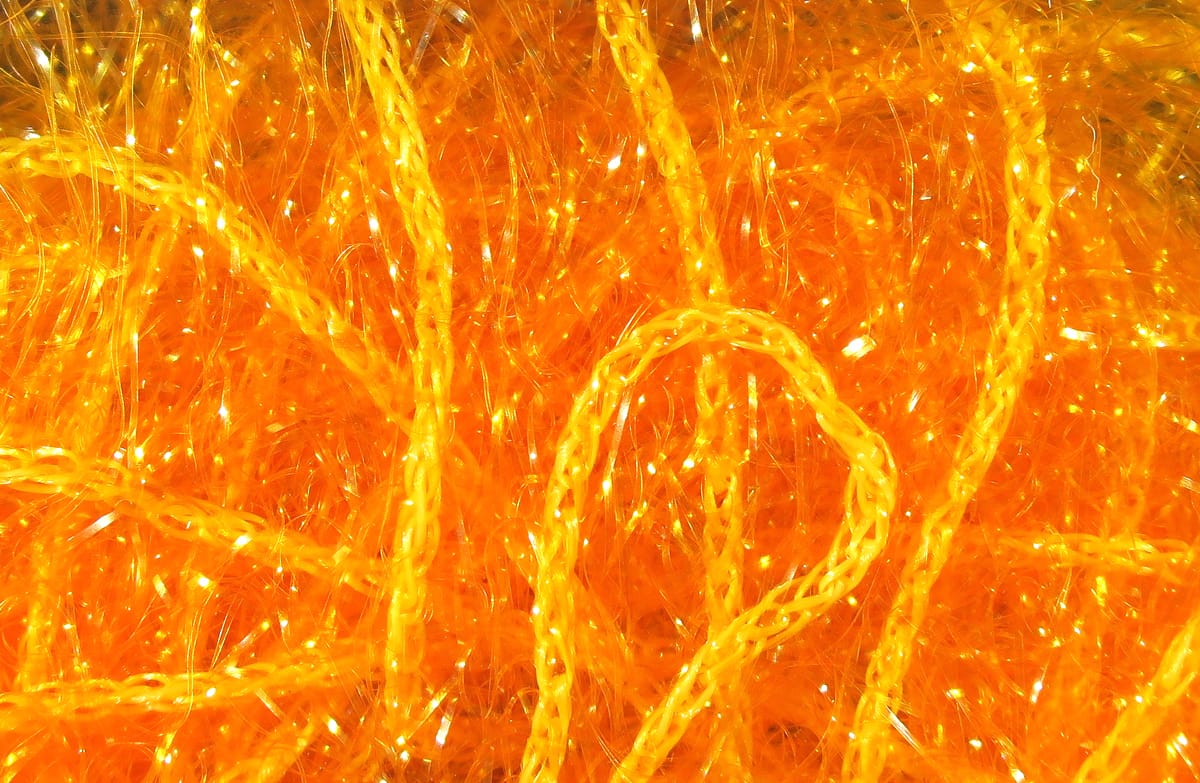 Bright orange Hareline Polar Chenille with braided core and sparkling iridescent synthetic fibers for fly tying