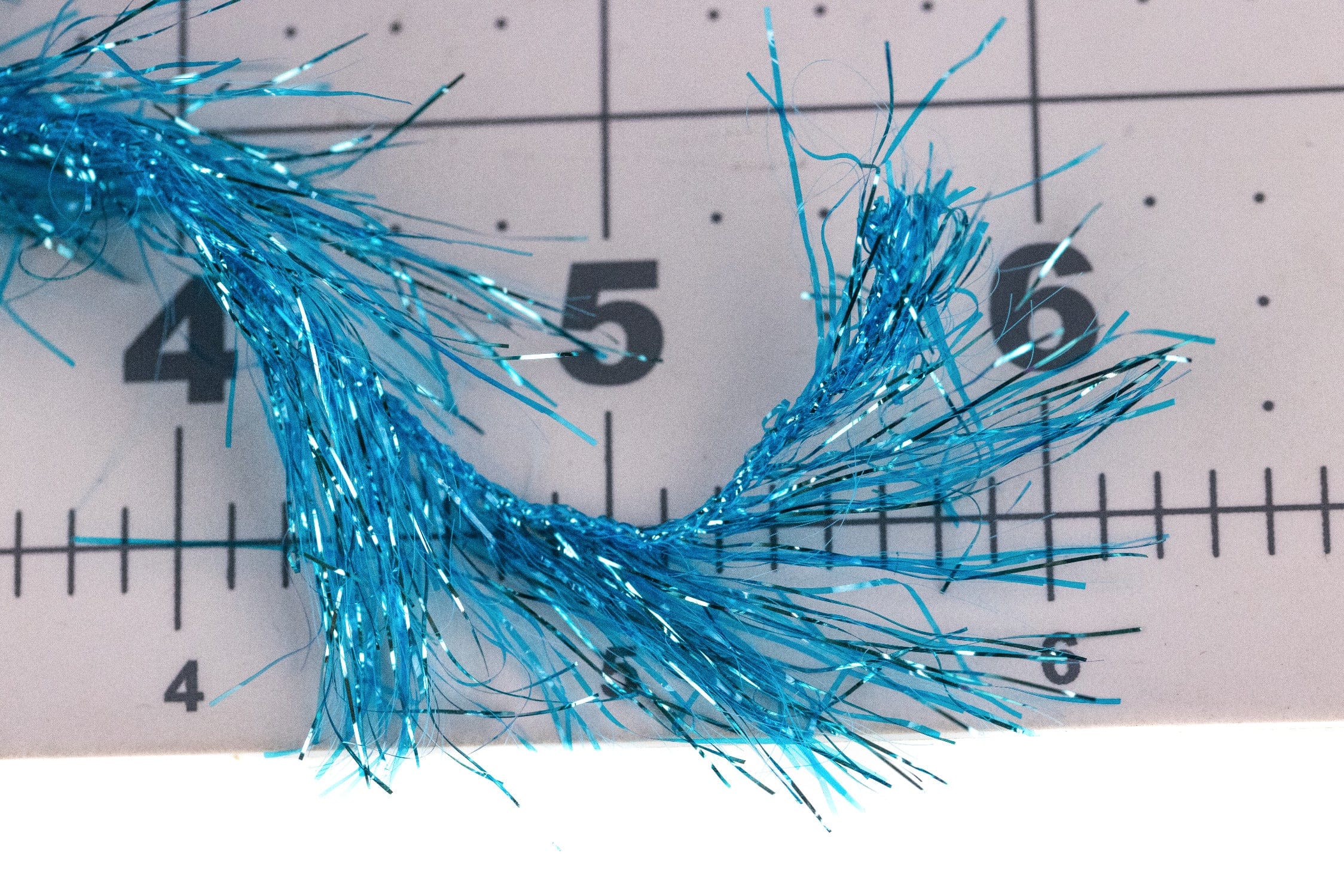 Bright turquoise Polar Reflector flash chenille with shimmering metallic tinsel strands and fringed fibers for fly tying