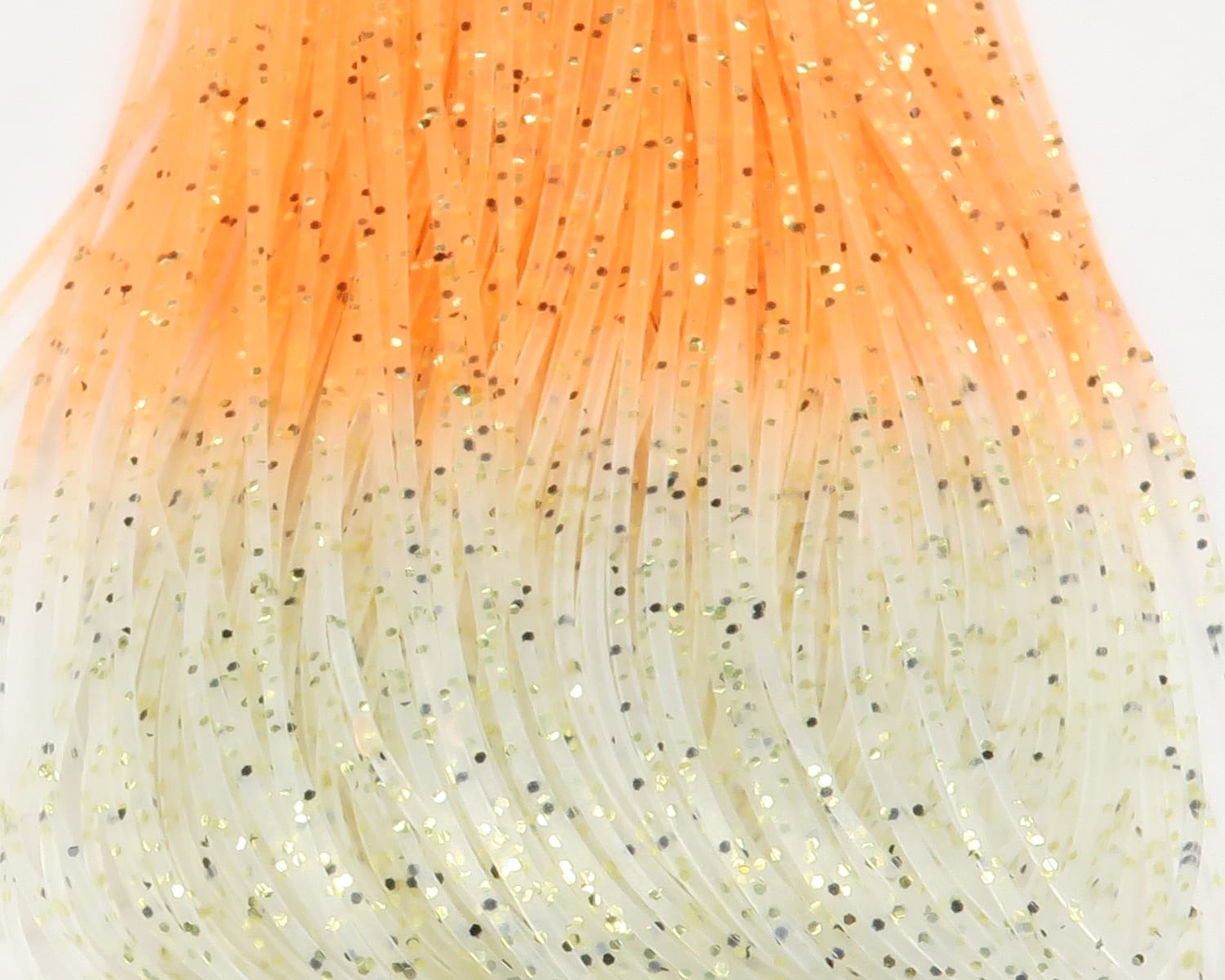 Translucent orange-to-cream synthetic shrimp/crabby legs strands with gold and black glitter flakes for fly tying
