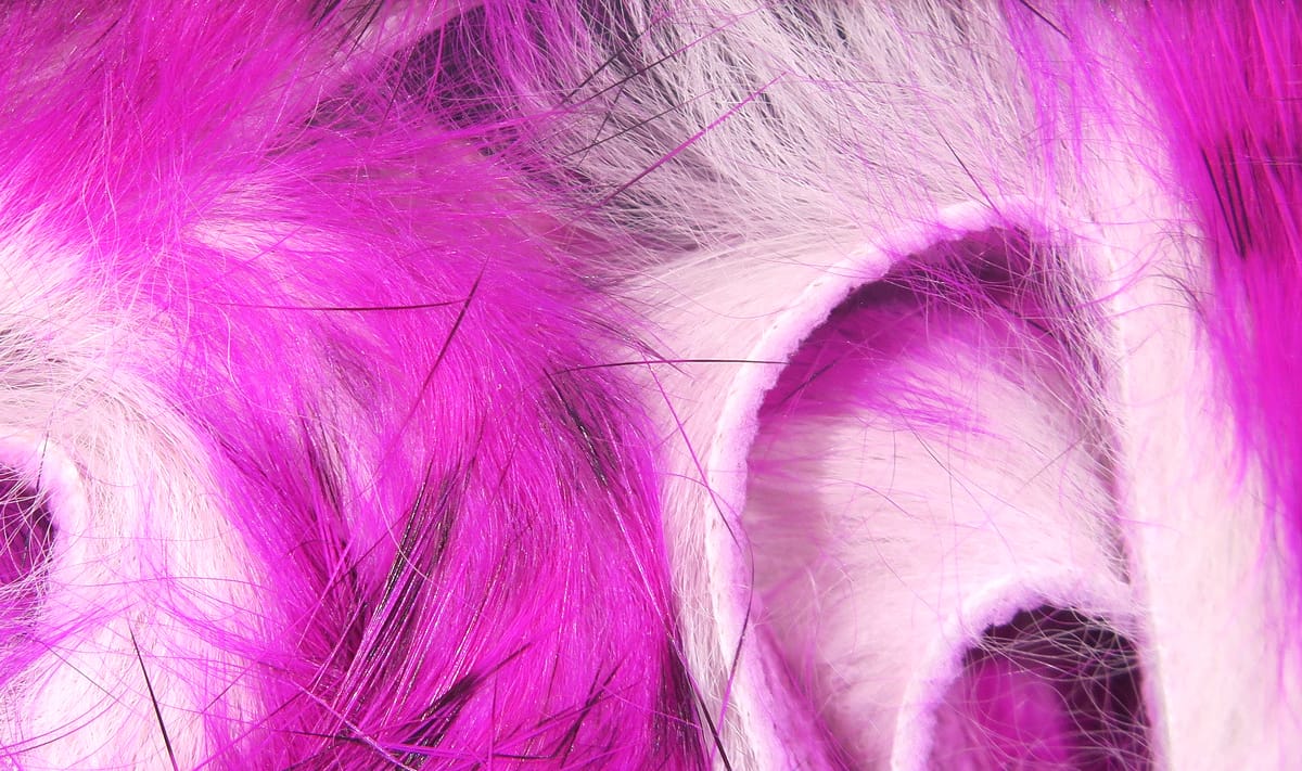 Bright magenta and white rabbit fur strips with black guard hairs, soft barred fur for fly tying