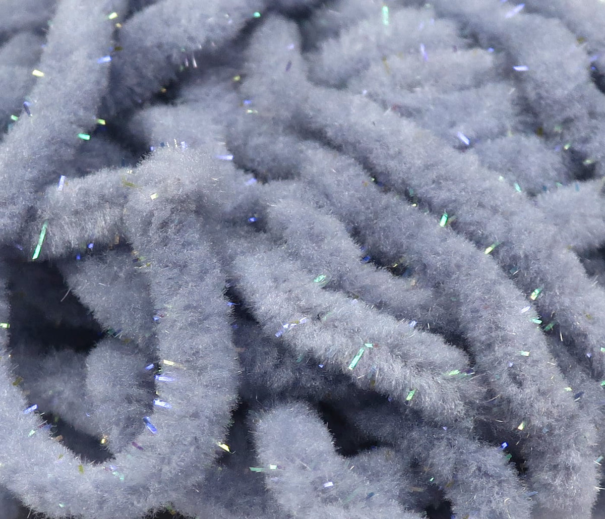 Soft gray mop chenille with fuzzy texture and scattered iridescent blue-green tinsel for fly tying