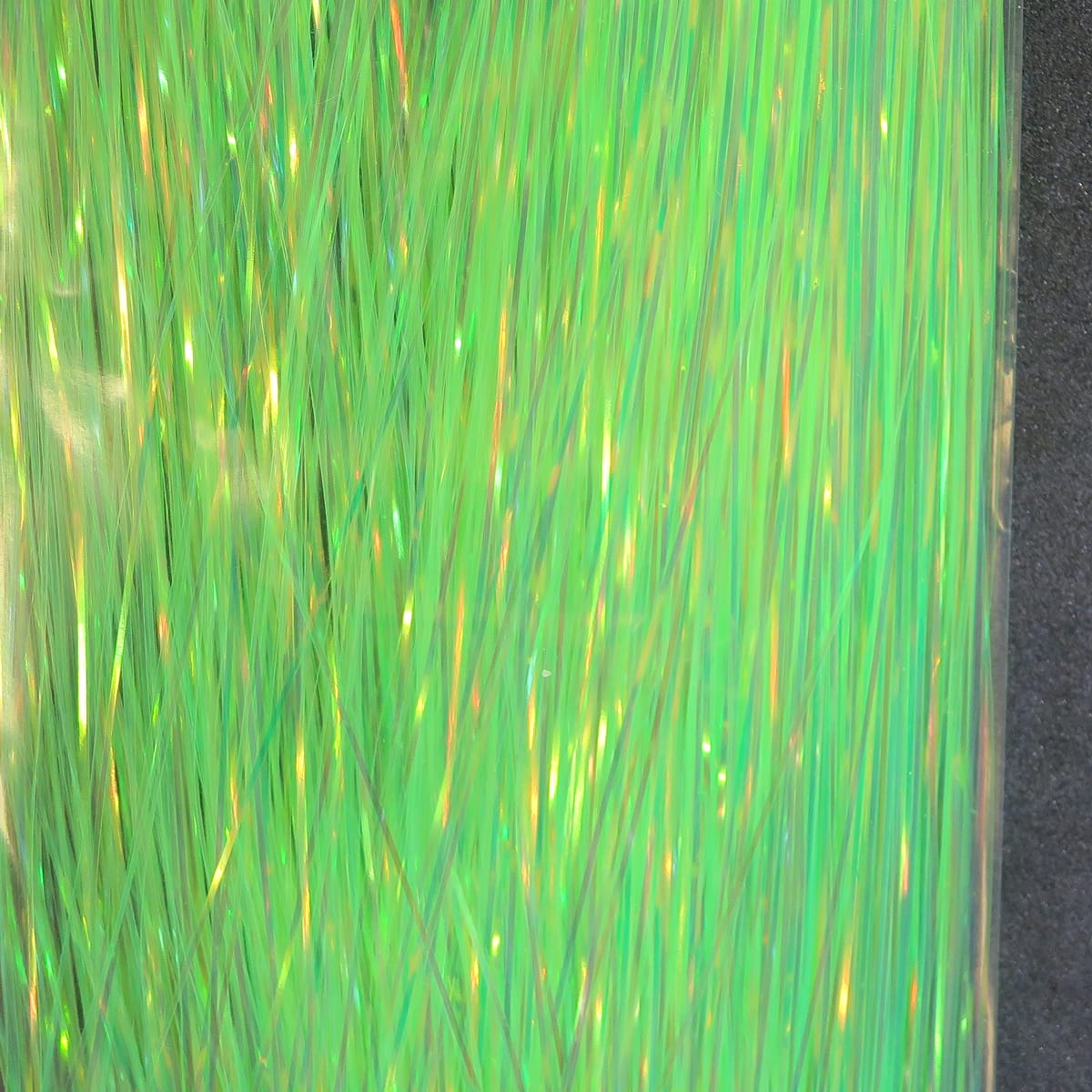 Dyed pearl Flashabou iridescent neon-green synthetic tinsel strands for fly tying with pearlescent shimmer
