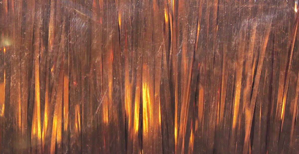 Copper-bronze Flashabou strands with golden iridescent metallic tinsel, wide magnum style synthetic fibers for fly tying