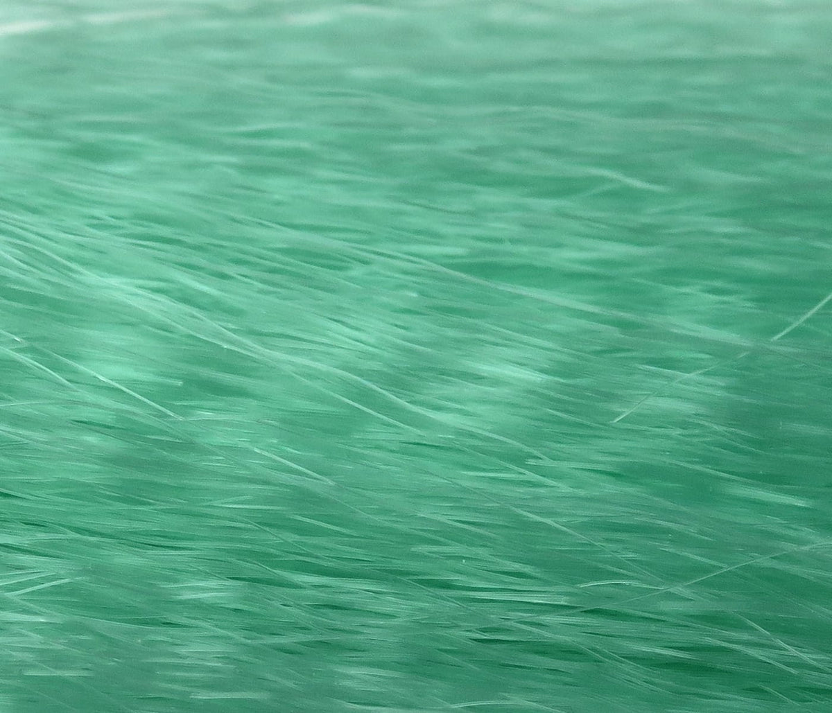 Mint green fly tying hair, fine silky synthetic strands with subtle sheen and layered texture