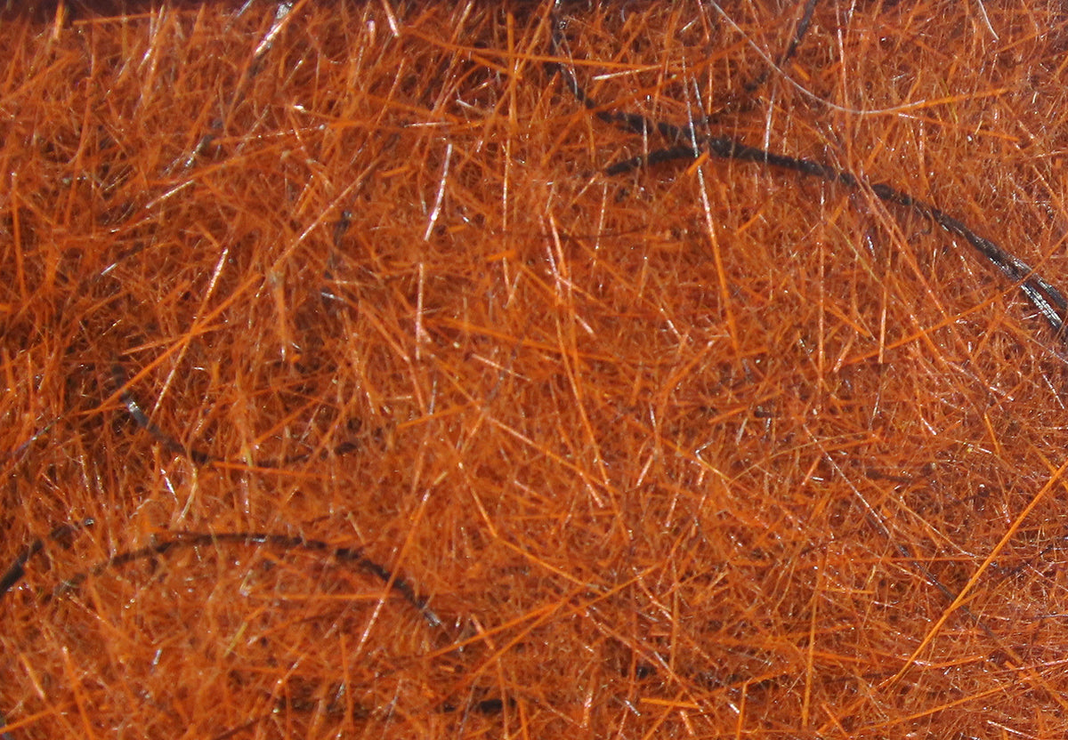 Bright orange Hareline Wiggle Dub dubbing fibers with thin black guard hairs and subtle iridescent strands for fly tying