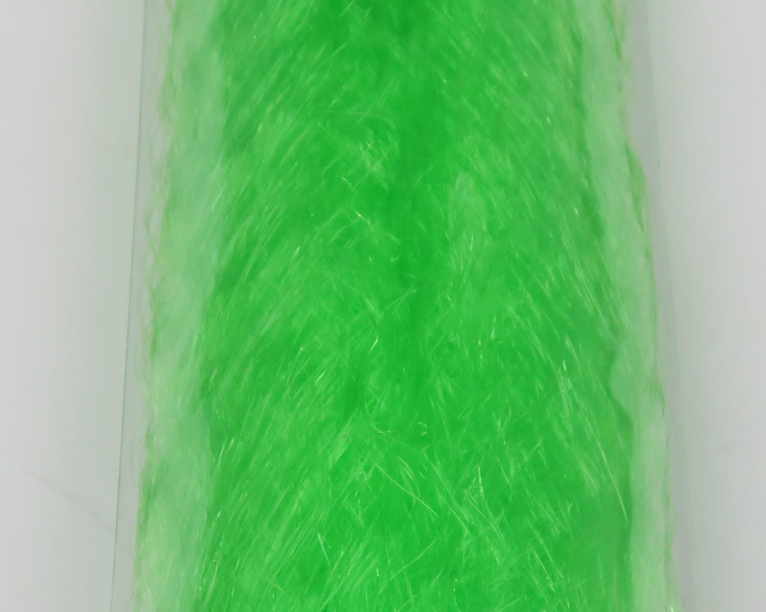 Bright neon green slinky fibre with glossy synthetic strands, bundled for fly tying, fine translucent texture