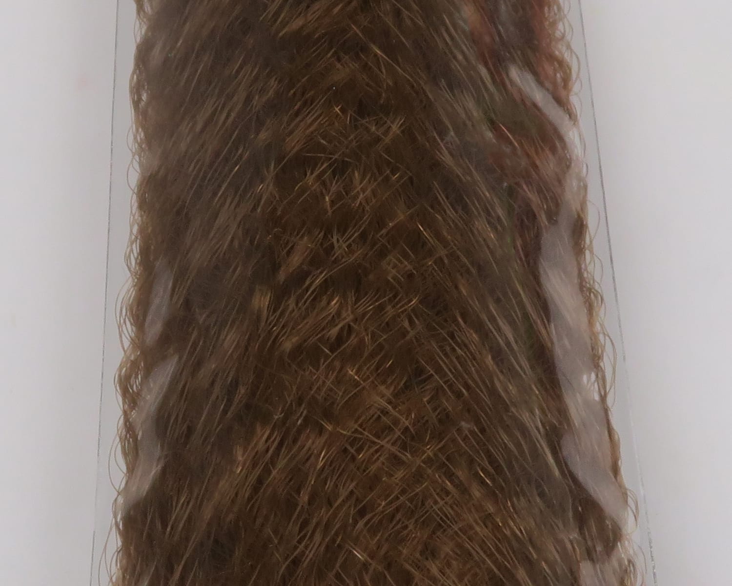 Brown slinky synthetic fibre for fly tying, wavy glossy strands with fine texture