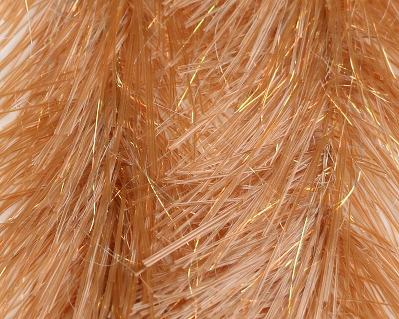 Peach translucent synthetic fly brush with fine glossy strands and gold tinsel accents for fly tying