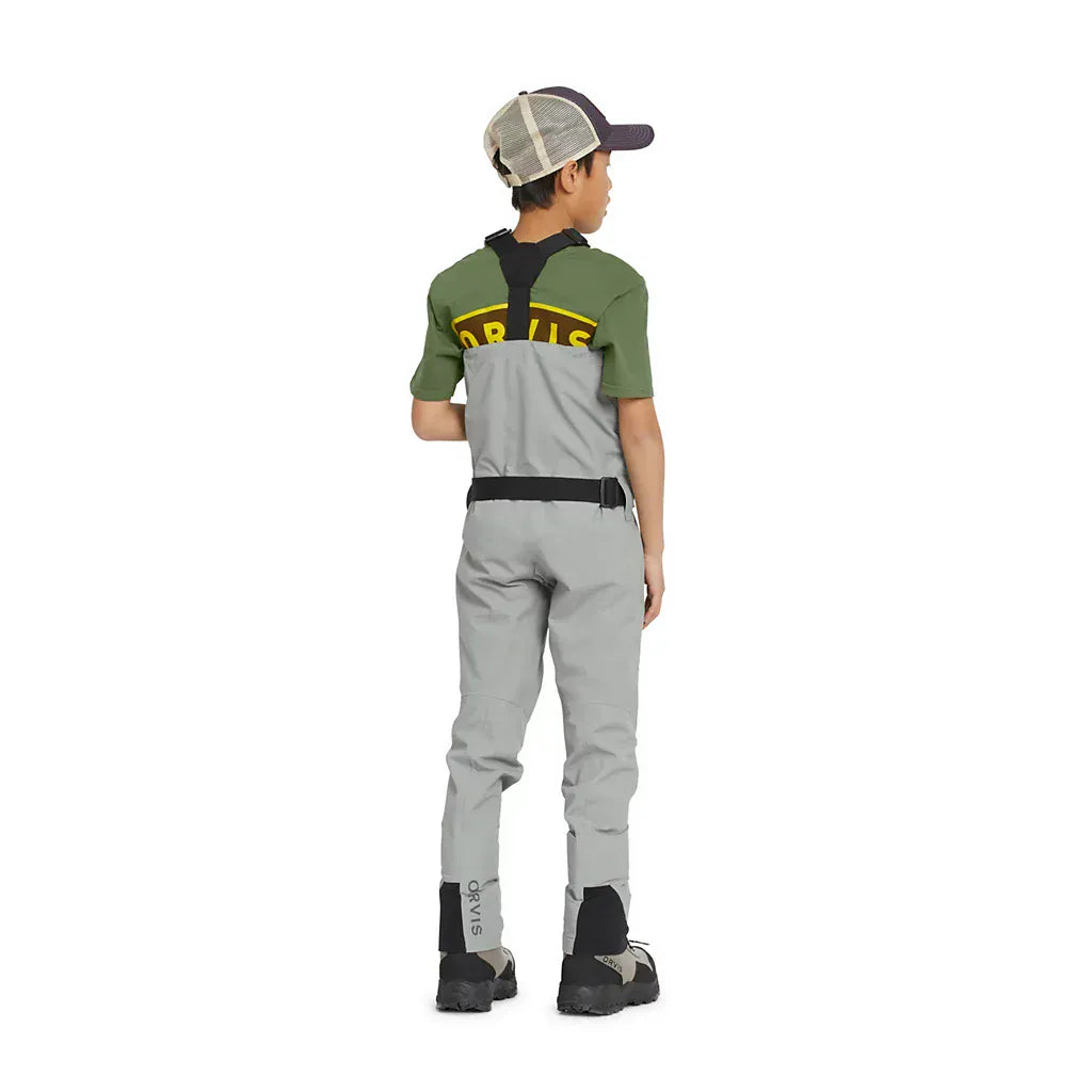 Rear view of child wearing Orvis kids gray chest waders with black suspenders, waist belt and reinforced ankle panels
