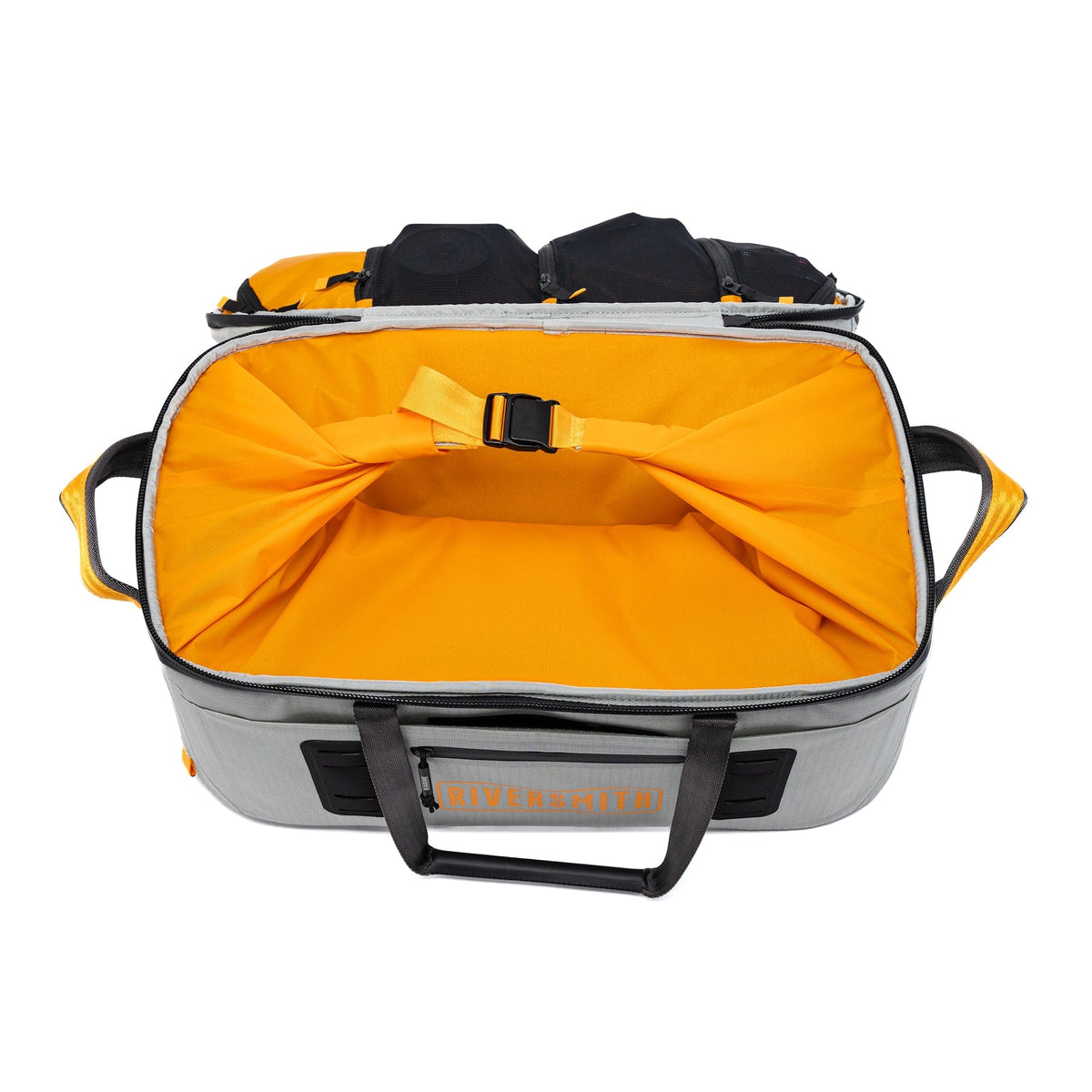 Riversmith waterproof duffel bag open showing bright orange interior, gray exterior with black handles and straps