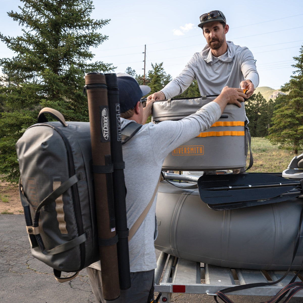 Riversmith Duffel waterproof bag in gray with orange straps displayed on boat trailer during outdoor adventure packing