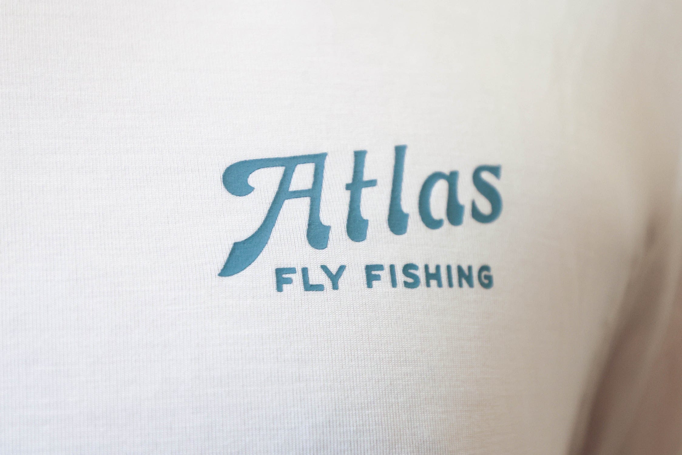 White bamboo sun hoodie with teal Atlas Fly Fishing chest logo, lightweight fishing hoodie
