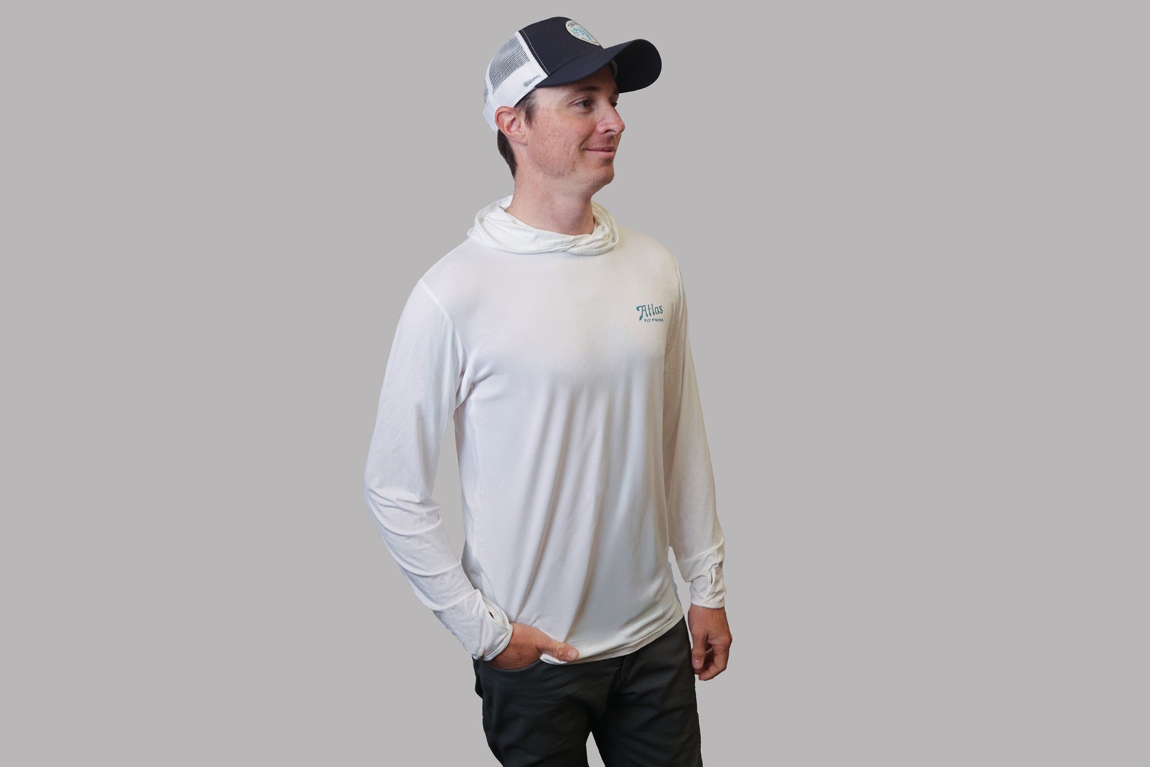 Man wearing white bamboo sun hoodie with long sleeves and hooded neck gaiter, Atlas fly fishing logo, lightweight