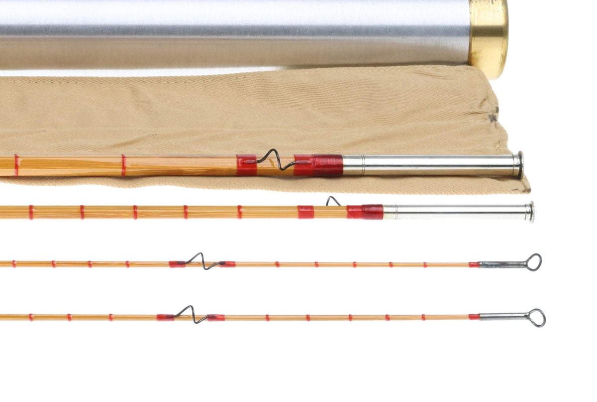 Vintage honey bamboo fly rod with red thread wraps, wire snake guides and metal ferrules on tan sleeve and metal tube