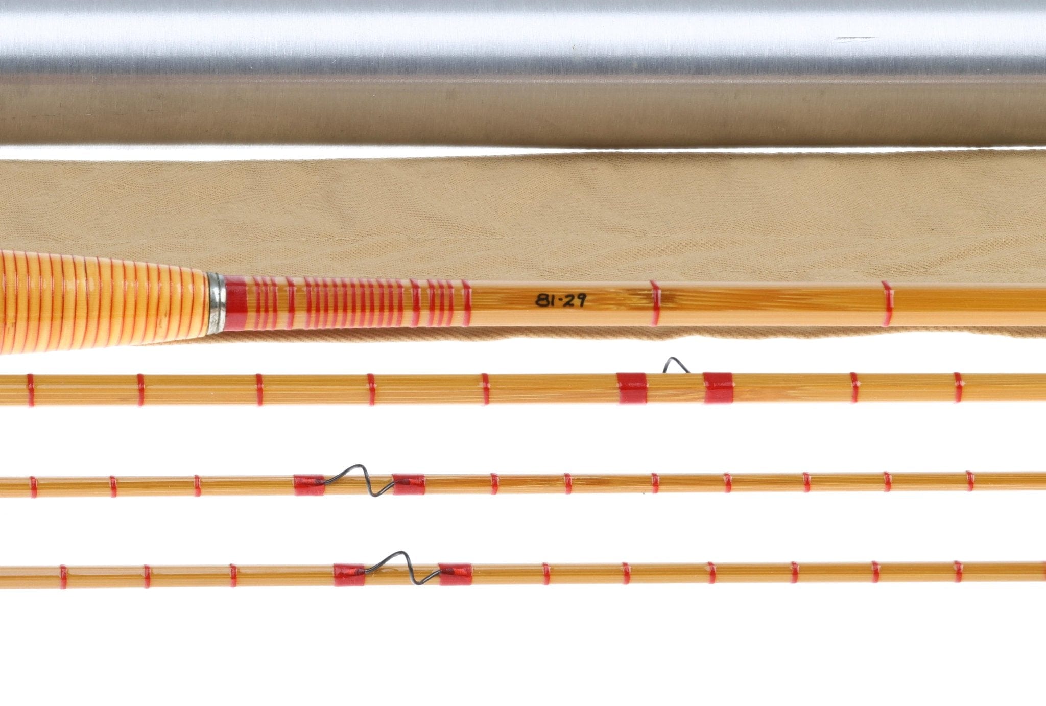 Honey-brown bamboo fly rod sections with red thread wraps, orange striped grip and silver ferrule, vintage style